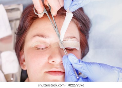 Female surgeon applies a bandage to the female patient's eyelids after a blepharoplasty operation. Close up portrait