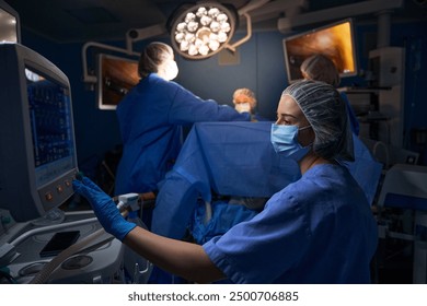 Female surgeon looking at monitor in operating room - Powered by Shutterstock