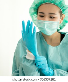 Female surgeon or nurse wearing a sterile green suit putting on sterile rubber gloves to perform a surgery, Hand wearing a surgical gloves before starting the operation, Step by step procedures.