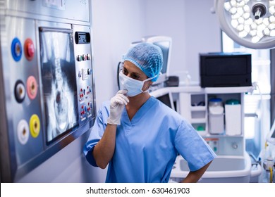 Female surgeon reading x-ray in operation theater. Healthcare workers in the Coronavirus Covid19 pandemic
