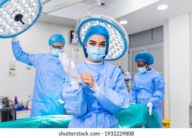 Female surgeon with surgical mask at operating room. Young woman doctor in surgical uniform in hospital operation theater.
