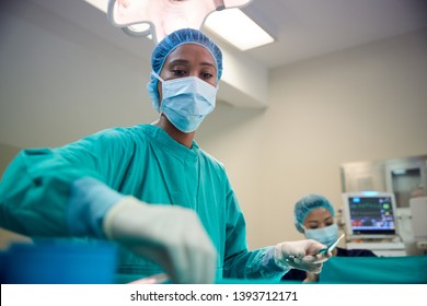 Female Surgical Team Working On Patient In Hospital Operating Theatre