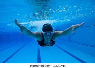 Female Swimmer Diving Underwater In Swimming Pool