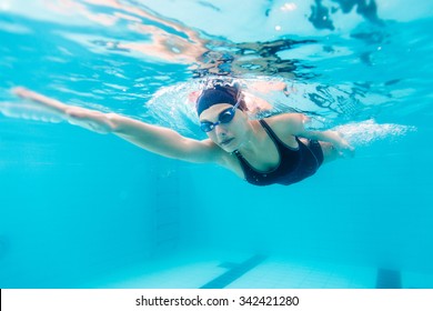 Female swimmer gushing through water in pool - Shutterstock ID 342421280