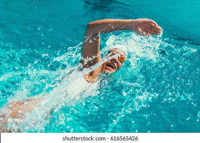 Female swimmer on training in the swimming pool. Front crawl swimming style