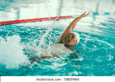 Female swimmer on training in the swimming pool. Backstroke swimming style - Powered by Shutterstock