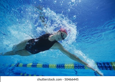 Female Swimmer Racing Underwater In Pool