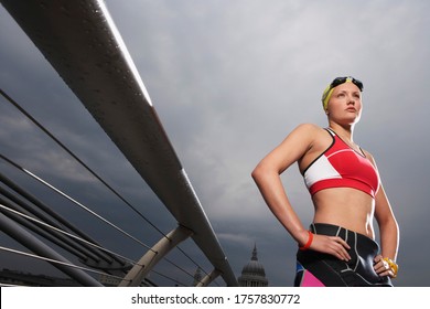 Female swimmer standing on foot bridge low angle view Millennium Bridge London England