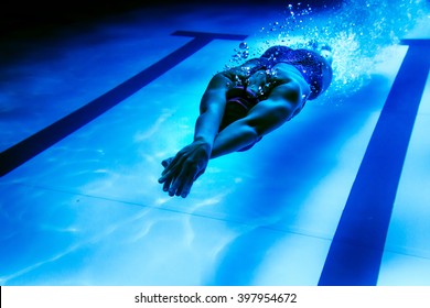 Female swimmer underwater/ Underwater shot of a swimmer diving after the jump in the swimming pool.  - Powered by Shutterstock