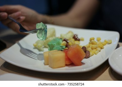 Female Take A Gelatin Salad With A Fork At The Restaurant Table