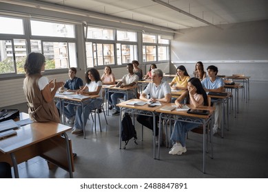 Female teacher in a class with a group of teenage, multi-ethnic students. High school, university - Powered by Shutterstock