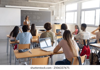 Female teacher explaining science to a class of diverse teenage students. High school, college, students in class - Powered by Shutterstock