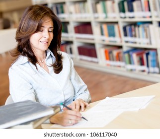 Female Teacher Grading Exams At The Library