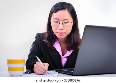 Female Teacher Grading Exams At The Room