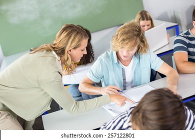 Female Teacher Helping Student In Her Class