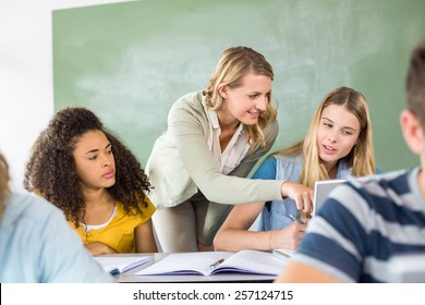 Female Teacher Helping Student In Her Class