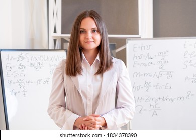 Female teacher. Online education. Webinar training. Business coaching. Smiling woman in formal clothes looking at camera flipchart boards on background.
