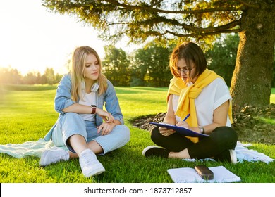 Female Teacher Psychologist Social Worker Talking To Teenage Student On The Lawn In The Park. Sociology, Psychology, Education, Youth Concept
