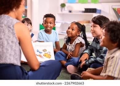 Female Teacher Reads To Multi-Cultural Elementary School Pupils Sitting On Floor In Class At School - Shutterstock ID 2267902663