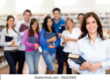 Female Teacher Smiling With A Group Of University Students