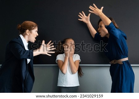 A female teacher and a student's mother yell at each other at the blackboard. The schoolgirl is crying.