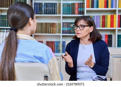 Female Teacher Talking To Teenage Student In The Library