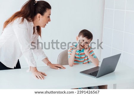 Female teacher teaching boy to use computer