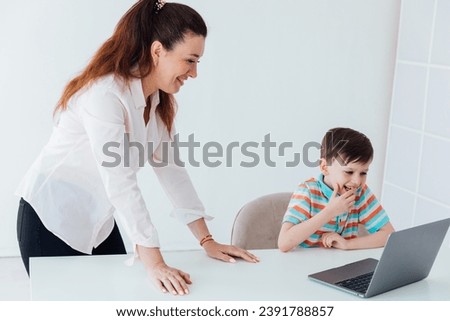 Female teacher teaching boy to use computer