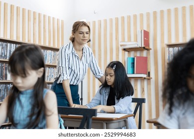 female teacher is teaching girls in class. School children education in classroom. kid schoolgirl happy learning. Writing as instructed by teacher. concept of back to school. - Powered by Shutterstock