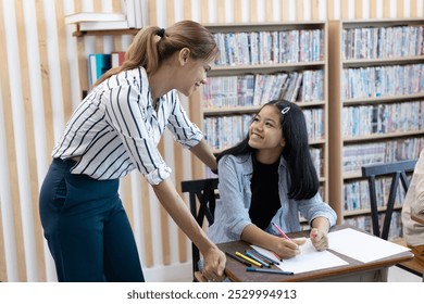 female teacher is teaching girls in class. School children education in classroom. kid schoolgirl happy learning. Writing as instructed by teacher. concept of back to school. - Powered by Shutterstock