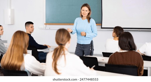 Female teacher teaching high school students in a school classroom - Powered by Shutterstock