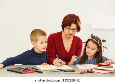 Female Teacher Teaching Mixed Race Kids Reading Book In Classroom,Kindergarten Pre School Concept
