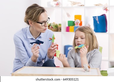 Female Teacher Using Colorful Toys During Play Therapy With Child