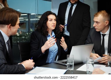 Female Team Leader At Business Meeting In Office, Talking To Managers, Checking Info On Laptop, Planning Strategy. Concept Of Buisness