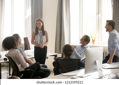 Female Team Leader Coach Talking To Diverse Business People At Office Meeting, Multiracial Employees Friendly Staff Group Having Fun Conversation Laughing Chatting At Corporate Training Or Briefing