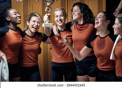 A Female Team At The Locker Room Posing And Celebrating The Won Trophy. Female Team Sport