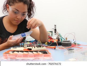 Female tech student learning how to wire a prototype circuit board