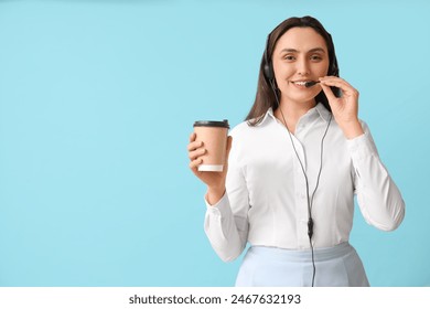 Female technical support agent in headset with paper cup of coffee on blue background