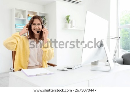 Female technical support agent at table in office