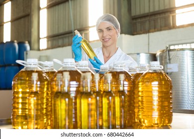 Female technician examining olive oil in factory - Powered by Shutterstock