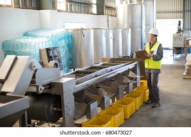 Female technician writing in clipboard at oil factory - Powered by Shutterstock