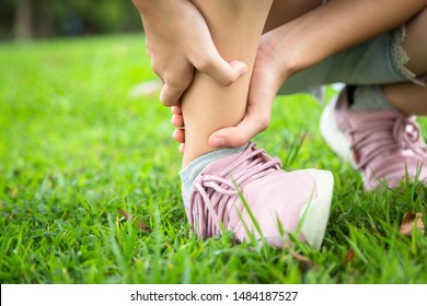 Female Teenager Hand Touching Painful Twisted,ankle Sprain,feel Ache,ankle Injury After Exercise At Park,asian Child Girl Have Leg Pain, Broken Ankle,problem,accident While Running,playing On The Lawn