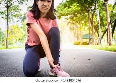 Female Teenager Hand Touching Painful Twisted Or Ankle Sprain,feel Ache,ankle Injury After Exercise At Park,asian Child Girl Have Leg Pain,problem,accident While Play On The Street,health Care Concept