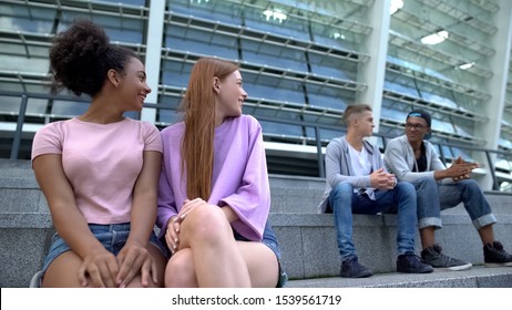 Female Teenagers Looking At Male Students Sitting Stairs, First Relations, Flirt