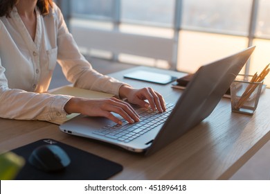 Teletrabajador femenino enviando mensajes de texto usando laptop e internet, trabajando en línea. Trabajador independiente escribiendo en casa, en el lugar de trabajo.