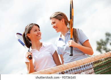 Female tennis players talking at a clay court - Powered by Shutterstock