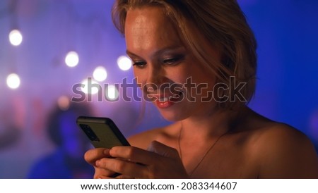Female texting on smartphone during party