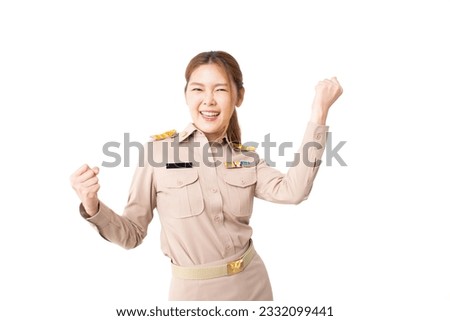 Female Thai government officer in khaki uniforms smiling. Beautiful woman doing winner gesture with arms raised isolated over white background. Concept of success in work, welfare, credit approval.