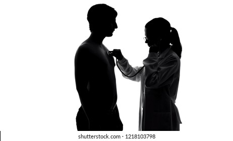 Female therapist examining male patient chest with stethoscope, health care - Powered by Shutterstock