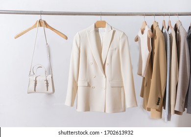 female three business formal jacket with long sleeved cotton T-Shirt ,vest and white handbag on hanging 
 - Powered by Shutterstock